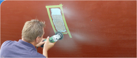 Nick Saull, the owner of Osmosis Solutions, inspects a laminate hull